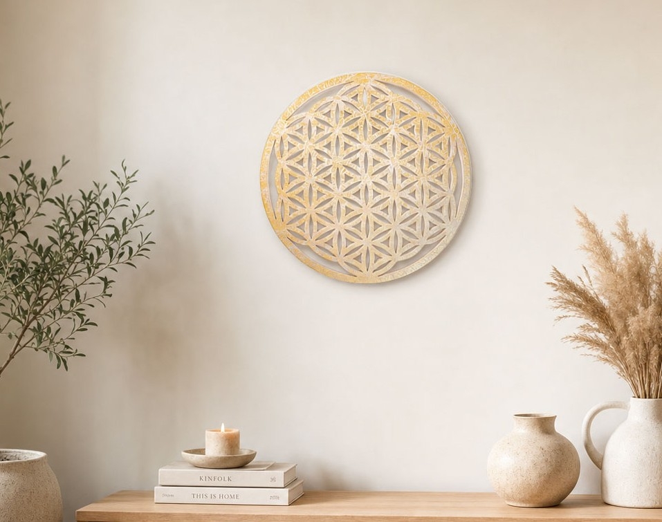 Runde Wanddekoration aus hellem Holz mit Blume-des-Lebens-Muster hängt über einer schlicht dekorierten Kommode.