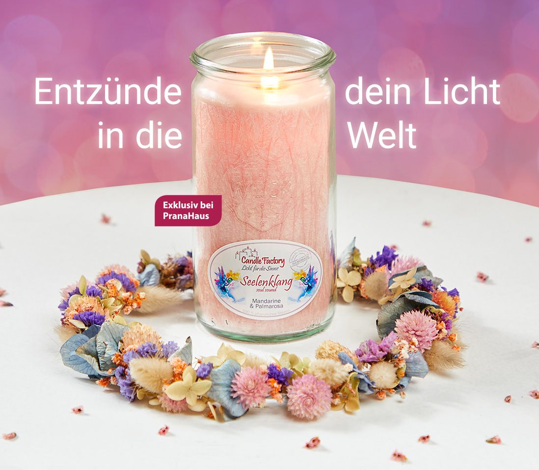 Eine brennende Duftkerze in einem rosa Weckglas steht auf einem Tisch, umgeben von einem bunten Blumenkranz. Daneben stehen die Worte "Entzünde dein Licht in die Welt".