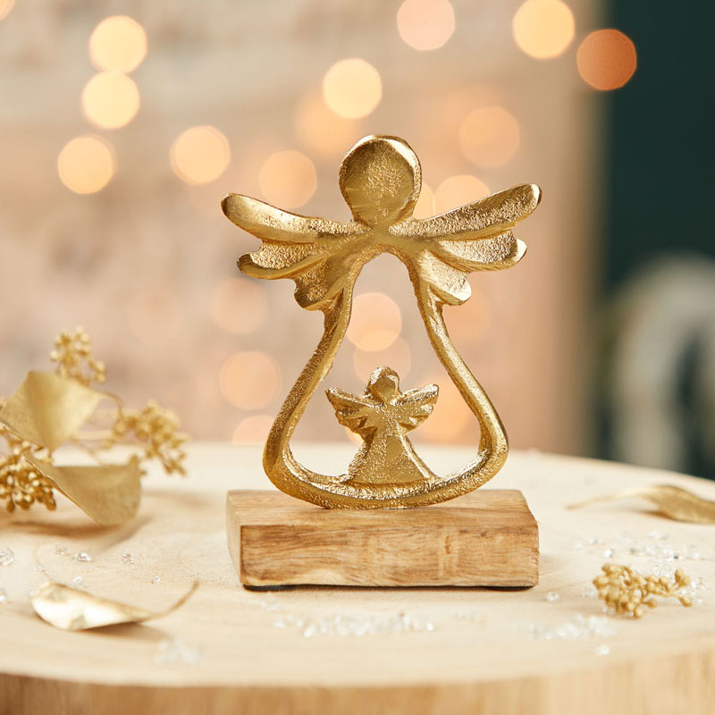 Ein goldener Schutzengel aus Metall auf einem Holzsockel