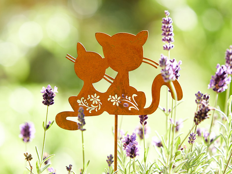 Rostfarbener Gartenstecker mit zwei Katzen zwischen blühendem Lavendel, verspielt und dekorativ im grünen Garten platziert.